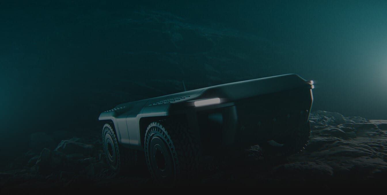 A four-wheeled, rugged robotic vehicle with headlights navigates a dark, rocky terrain, illuminated by faint blue light, suggesting an exploration or search mission in a low-light environment.