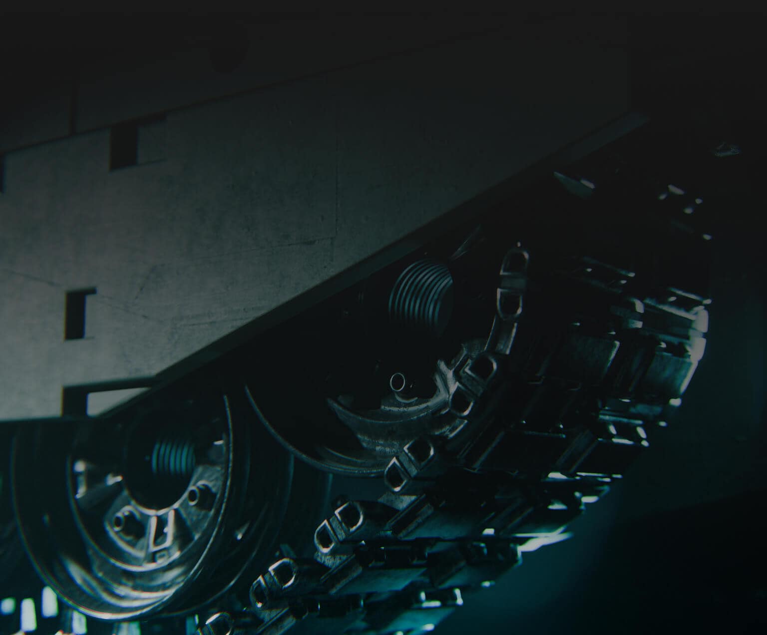 Close-up view of a tank’s metal tracks and wheels in dim lighting, showing mechanical details and a rugged, industrial texture.