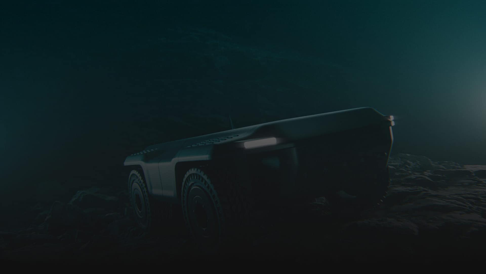 A dark, low-light image of a rugged, autonomous vehicle with large wheels and headlights, driving over rocky terrain. The scene appears to be set underwater or in a very dim environment.