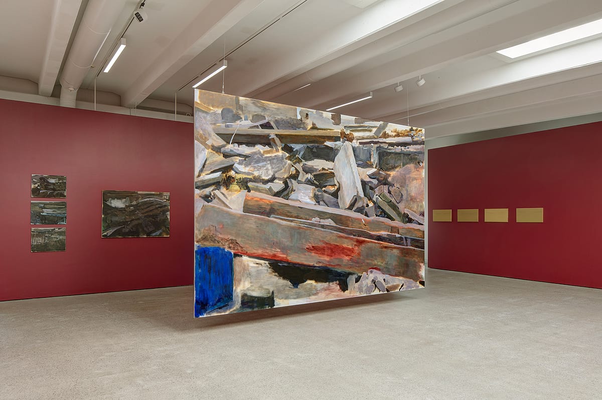 Installation view of ‘Thomas Nyqvist: Painovoima’. A large oil painting of a pile of construction materials suspended from the ceiling.