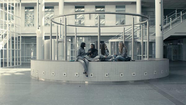 Four girls sitting on a bench in Itä-Pasila.