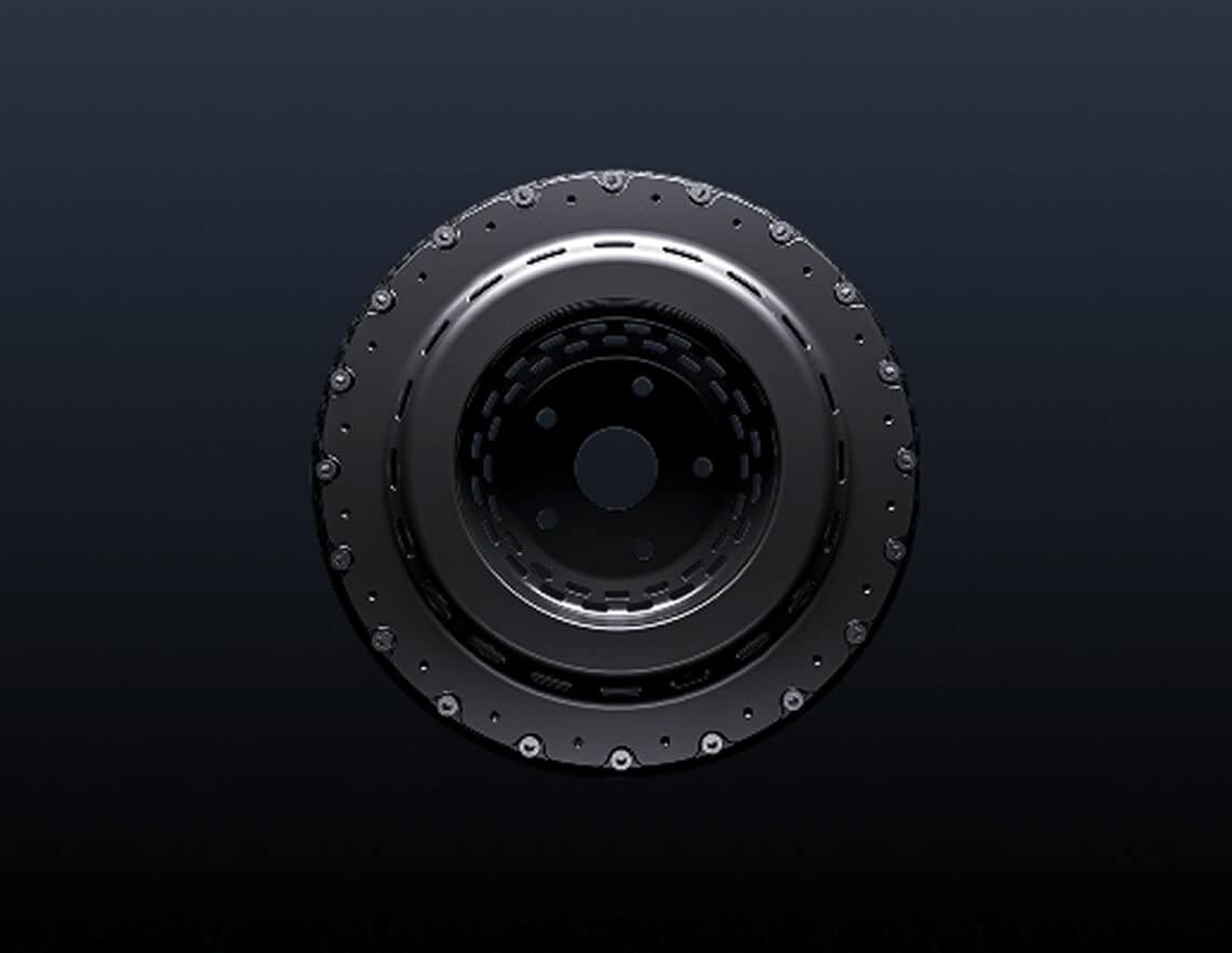 A close-up view of a metallic, circular mechanical part with bolts around its outer edge, set against a dark gradient background.