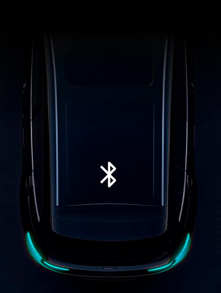 A top-view of a dark-colored car with a glowing Bluetooth symbol on the roof, surrounded by a dark background. The car's rear lights are slightly illuminated in a teal hue.
