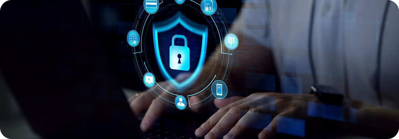 A person types on a laptop keyboard, with a digital overlay showing a glowing padlock icon inside a shield, surrounded by security and technology symbols, representing cybersecurity.