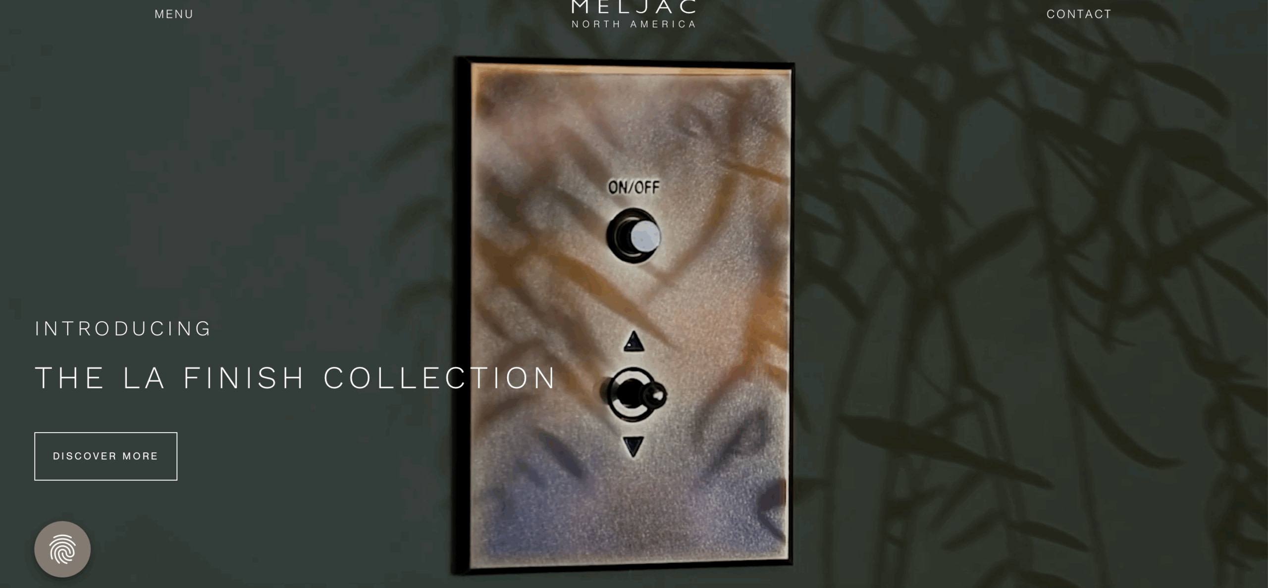 Meljac A decorative metallic light switch with toggle and button controls is displayed against a dark, leafy background. Text reads "Introducing The LA Finish Collection." A "Discover More" button appears below.