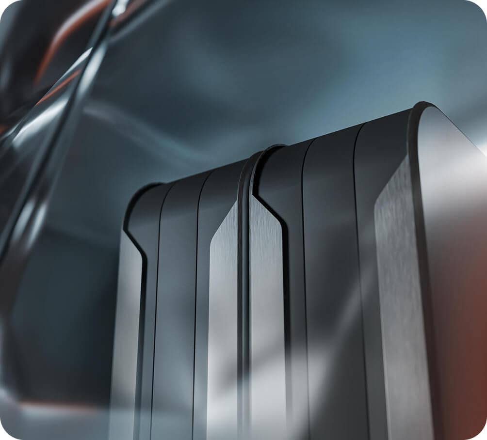Close-up of two sleek, metallic, rectangular objects with rounded corners and smooth edges, set against a blurred, abstract background with reflective surfaces and soft lighting.