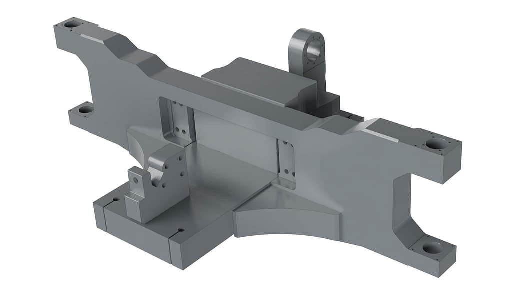 A gray, machined metal component with multiple flat surfaces, sharp edges, holes at the corners, and a raised, rectangular central section, possibly used as a mechanical or industrial part.