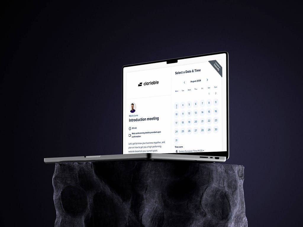 A laptop on a stone-like surface displays a scheduling app with a calendar and meeting details for an introduction meeting, against a dark background.