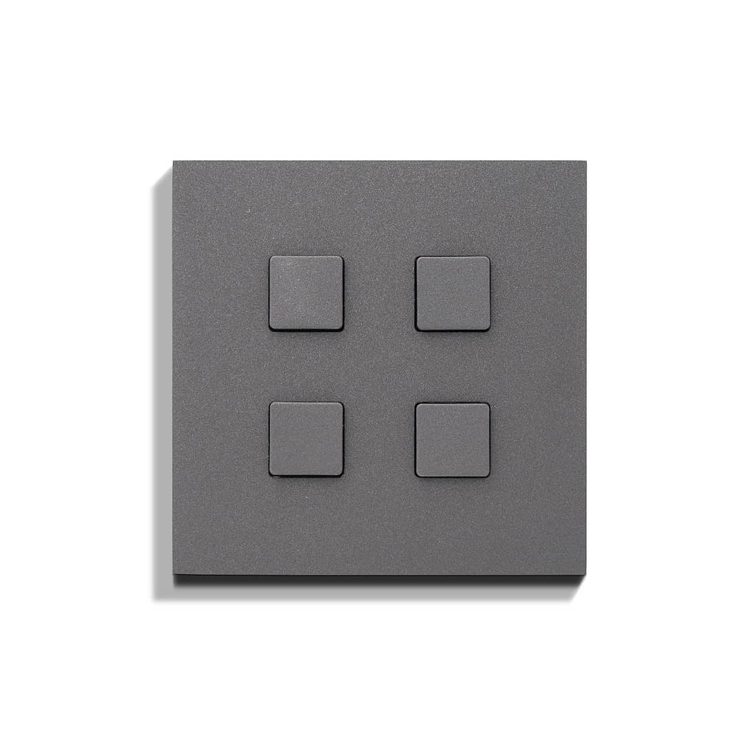 A grey wall plate with four squares on it.