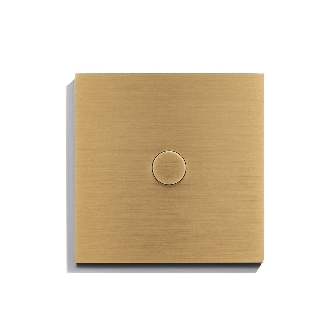 A gold light switch on a white surface.