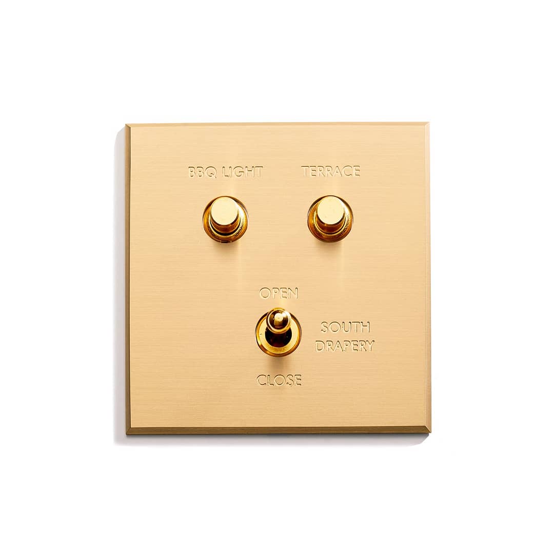 A gold switch with two buttons on it.