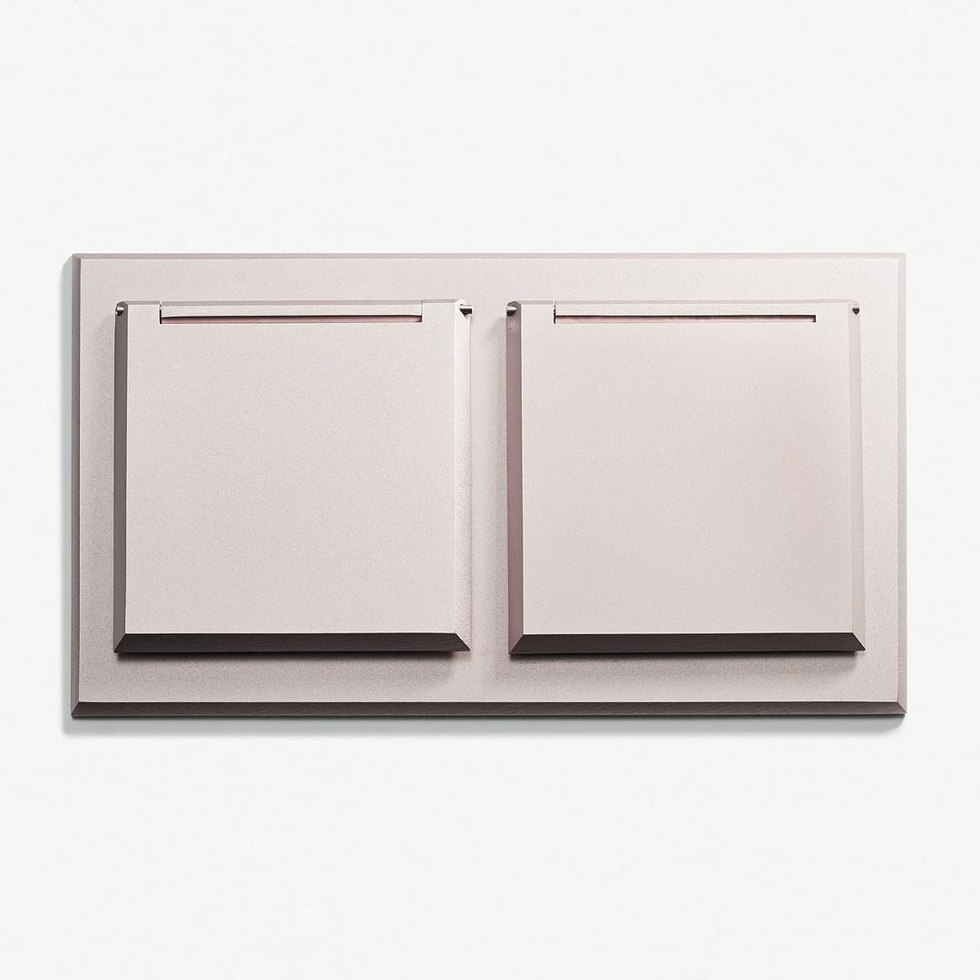 A wall mounted plate with two drawers on it.