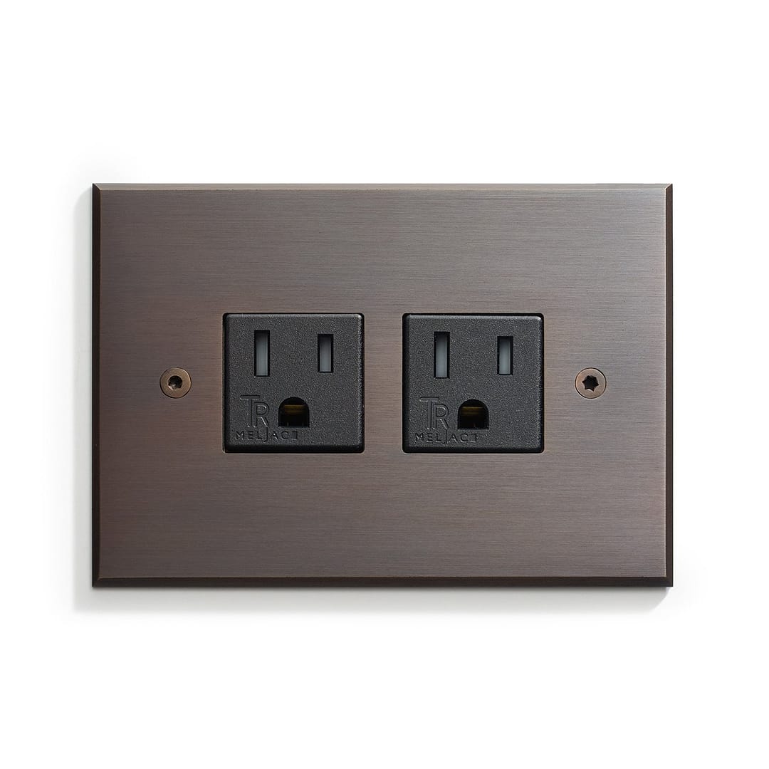 A brown wall plate with two outlets on it.