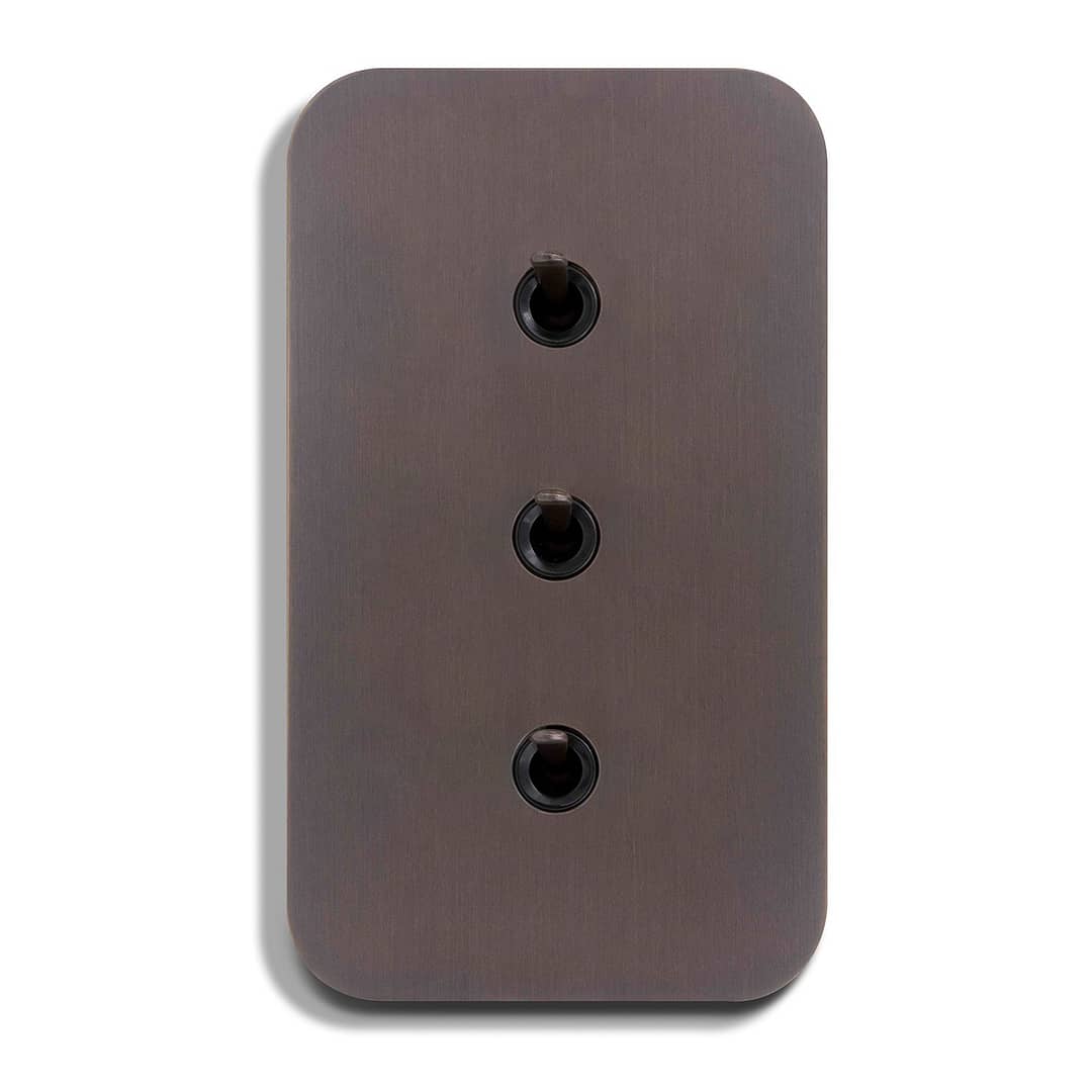 An image of a brown switch plate with three black buttons.