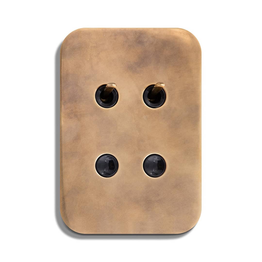 A brass plate with four holes on it.