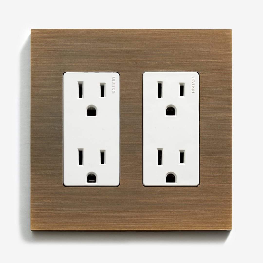 A modern dual electrical outlet with a wooden finish panel on a white background.