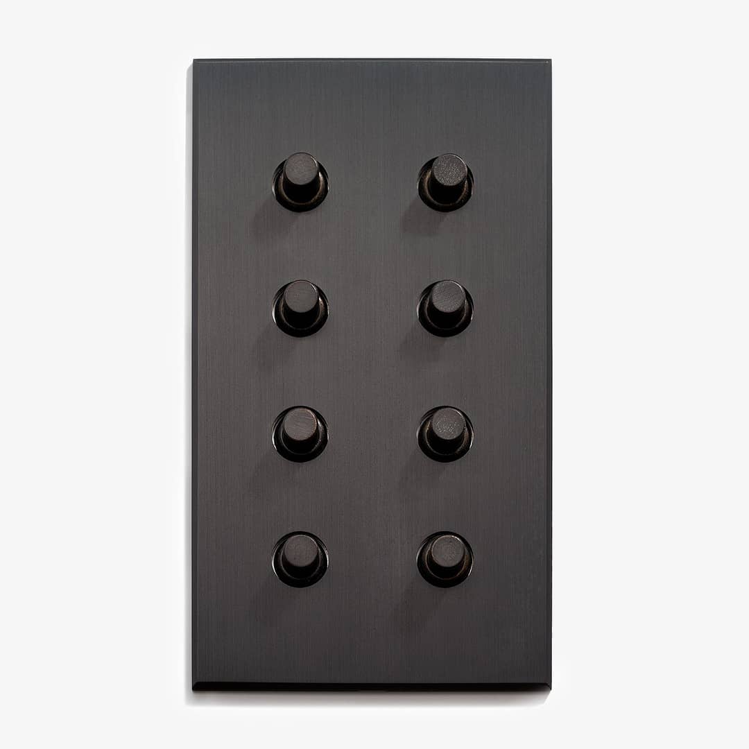 A sleek black panel featuring an array of nine circular buttons arranged in a grid on a white background.