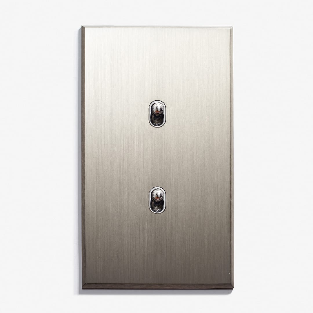 A brushed metal electrical faceplate with two keyhole shaped inserts.