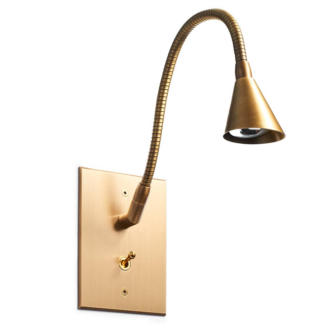Flexible brass wall lamp with a switch on an isolated white background.
