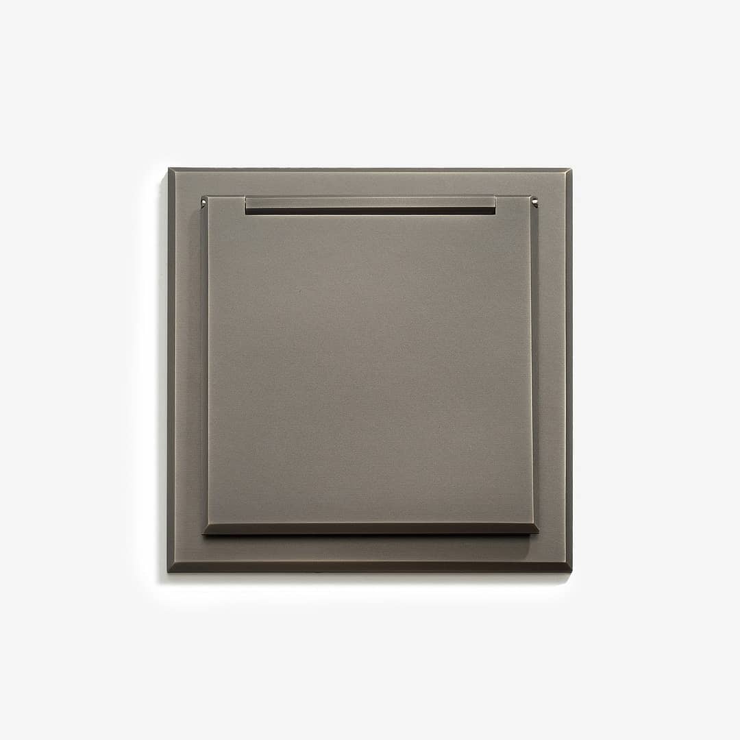 Modern square-shaped wall-mounted switch or socket plate on a white background.
