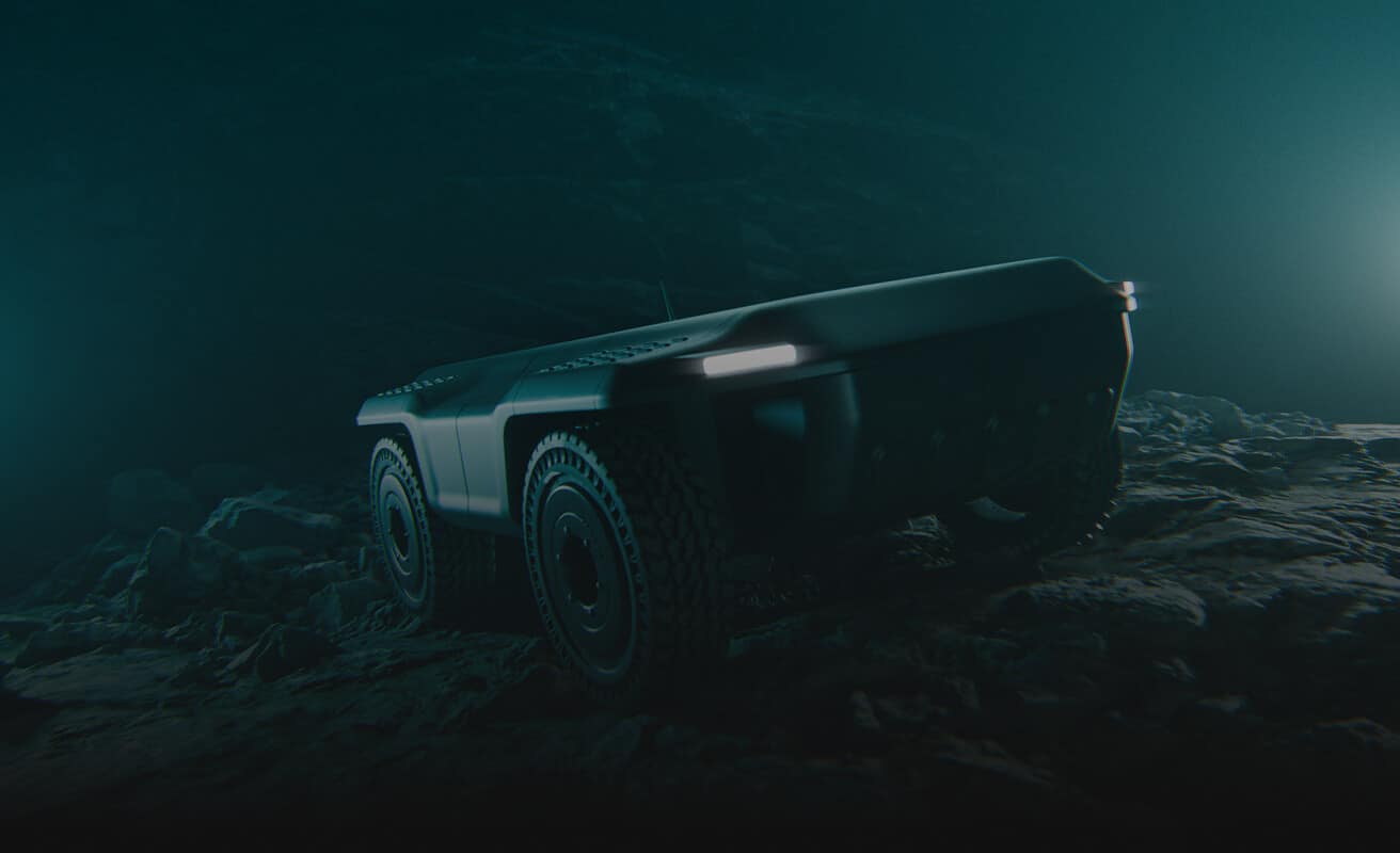 A rugged, futuristic, four-wheeled autonomous rover with illuminated lights navigates a rocky, dimly lit terrain, surrounded by darkness and subtle bluish lighting.