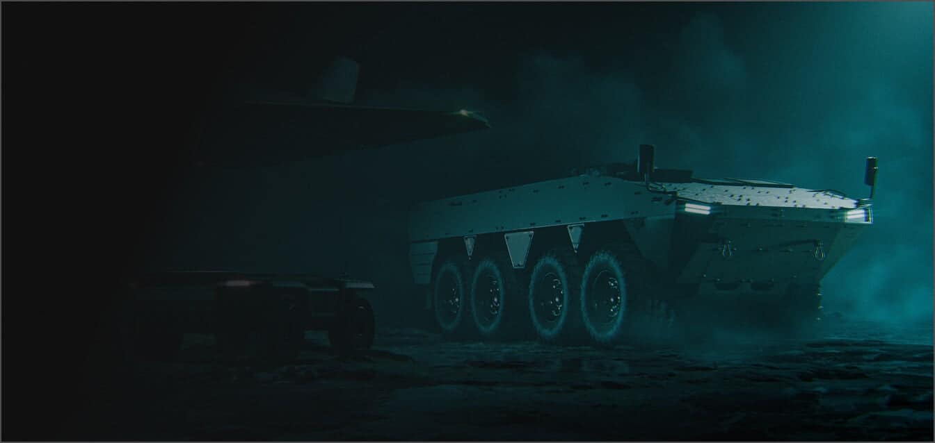 A large, armored, eight-wheeled military vehicle is parked on rough terrain at night, illuminated by faint green-blue lighting with mist or smoke in the air. Another smaller vehicle appears partially visible on the left.