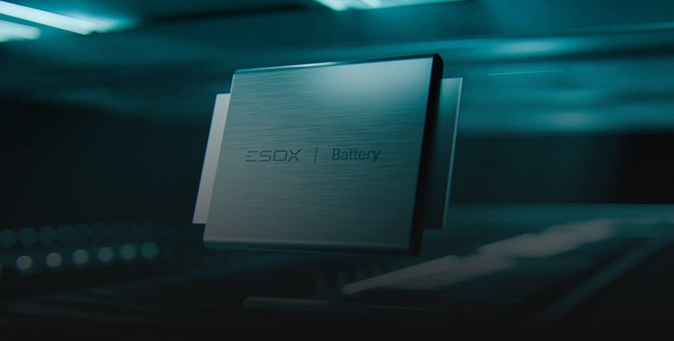 A metallic, rectangular battery with "SDX Battery" written on it floats in a dimly lit, futuristic setting with blue tones and blurred background details.