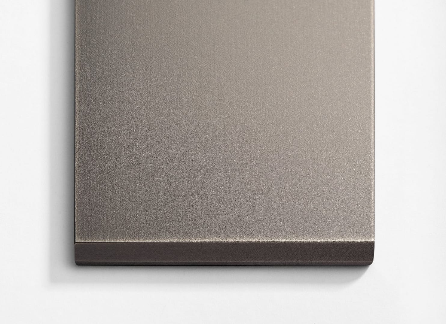 A stainless steel plate on a white wall.