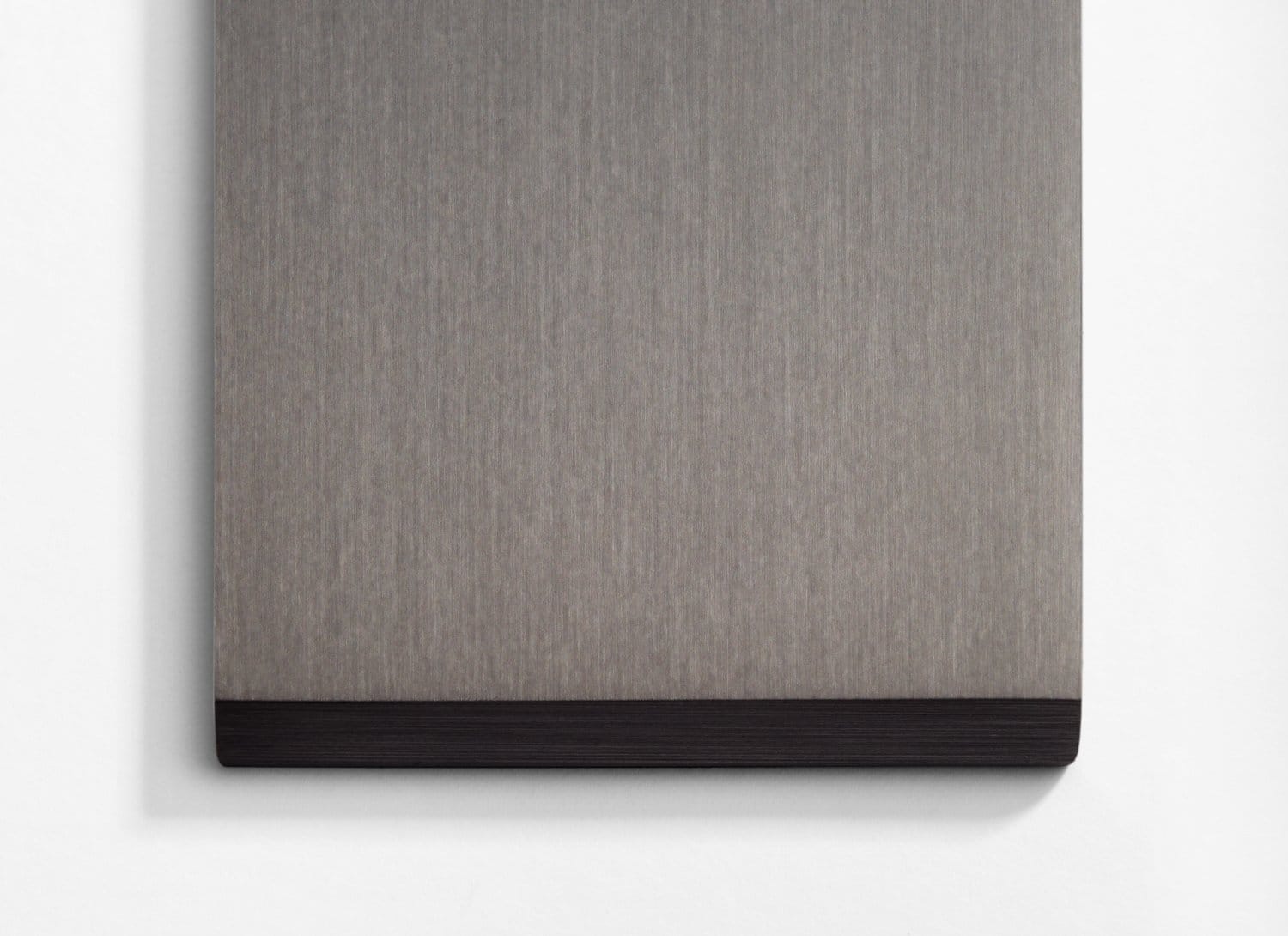 A gray and black piece of wood hanging on a wall.