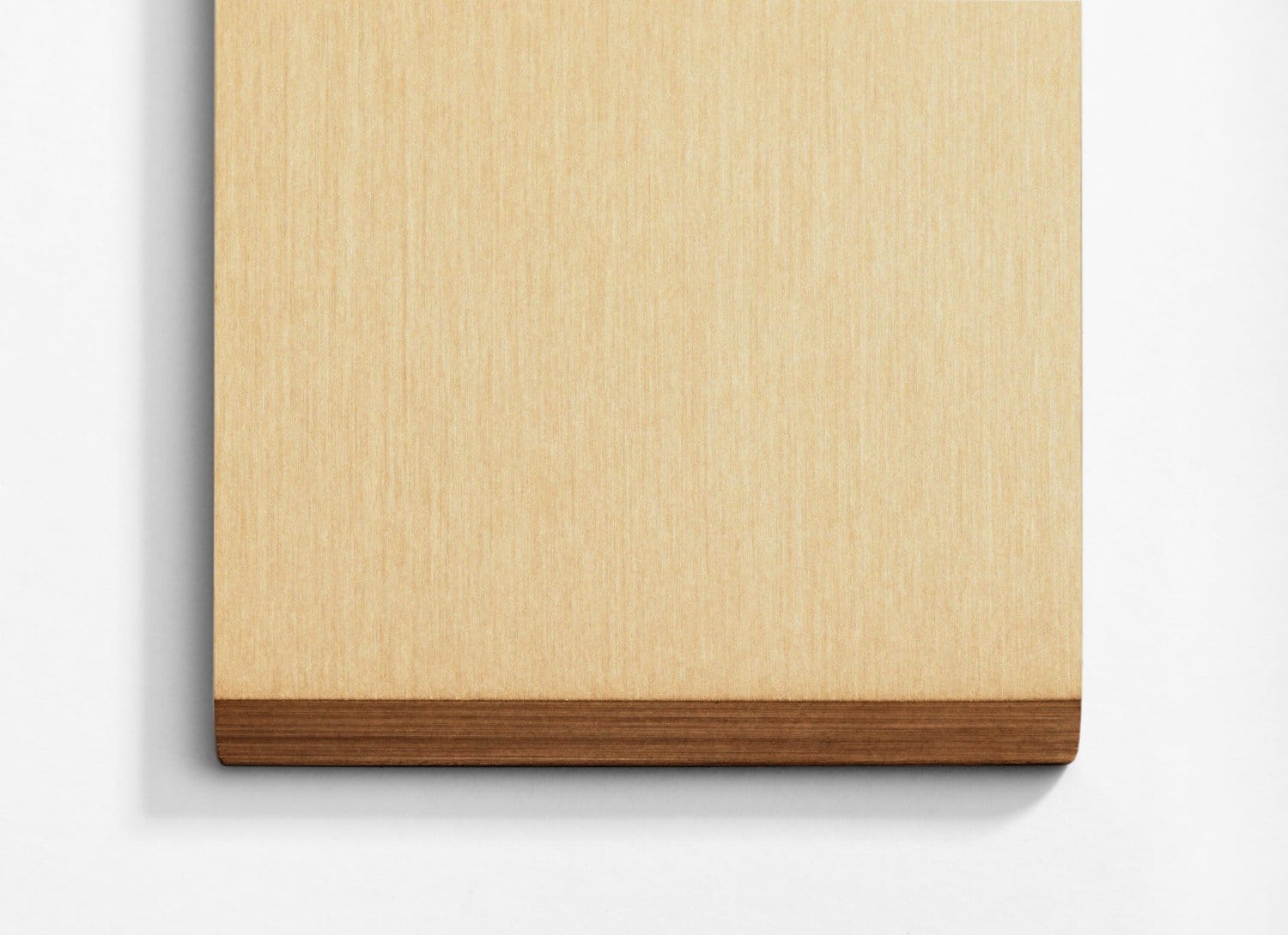 A wooden cutting board on a white wall.