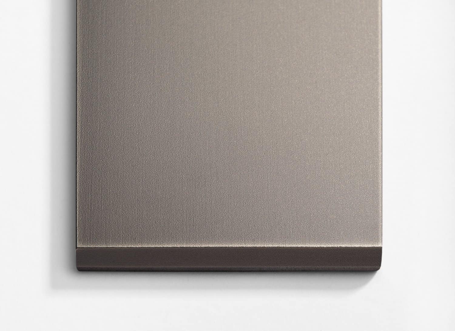A stainless steel plate on a white wall.