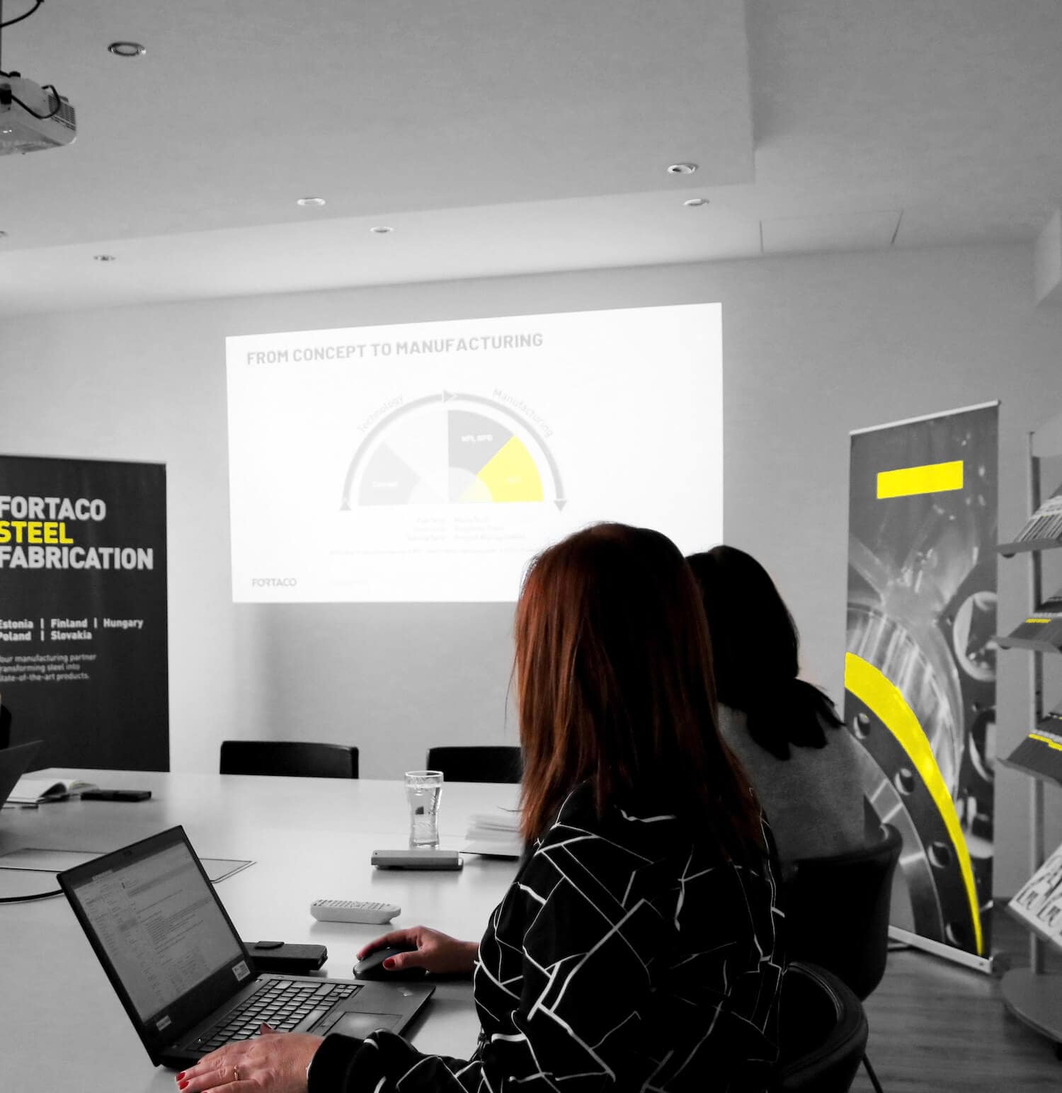 A group of people sitting in a conference room.