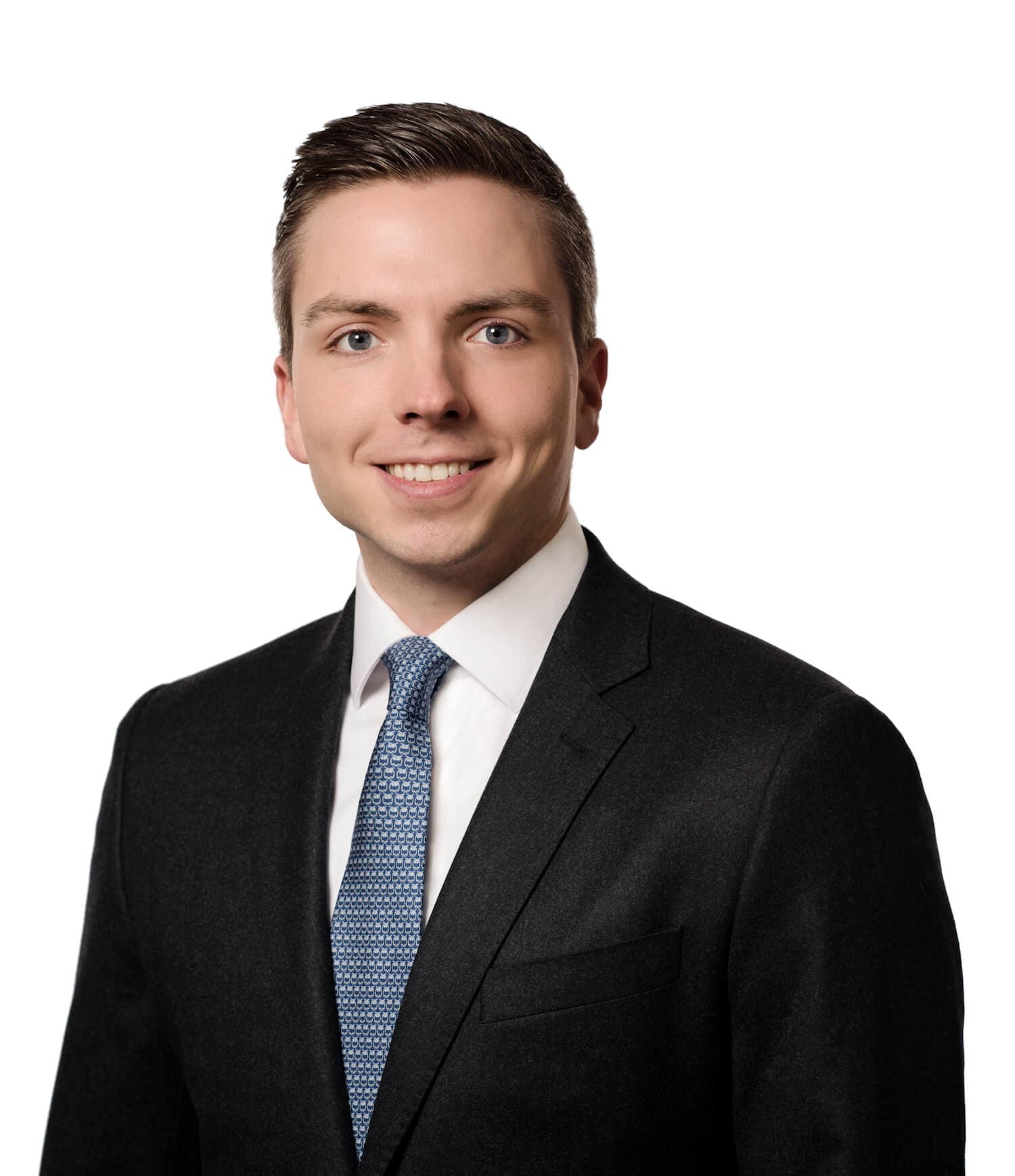 Pukuun ja solmioon pukeutunut mies poseeraa valokuvassa.