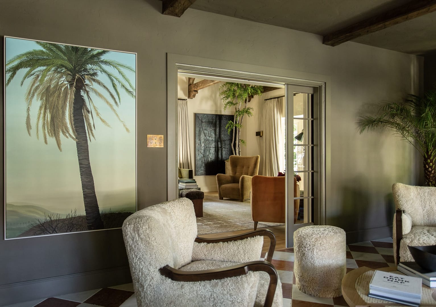 A living room with a palm tree on the wall.
