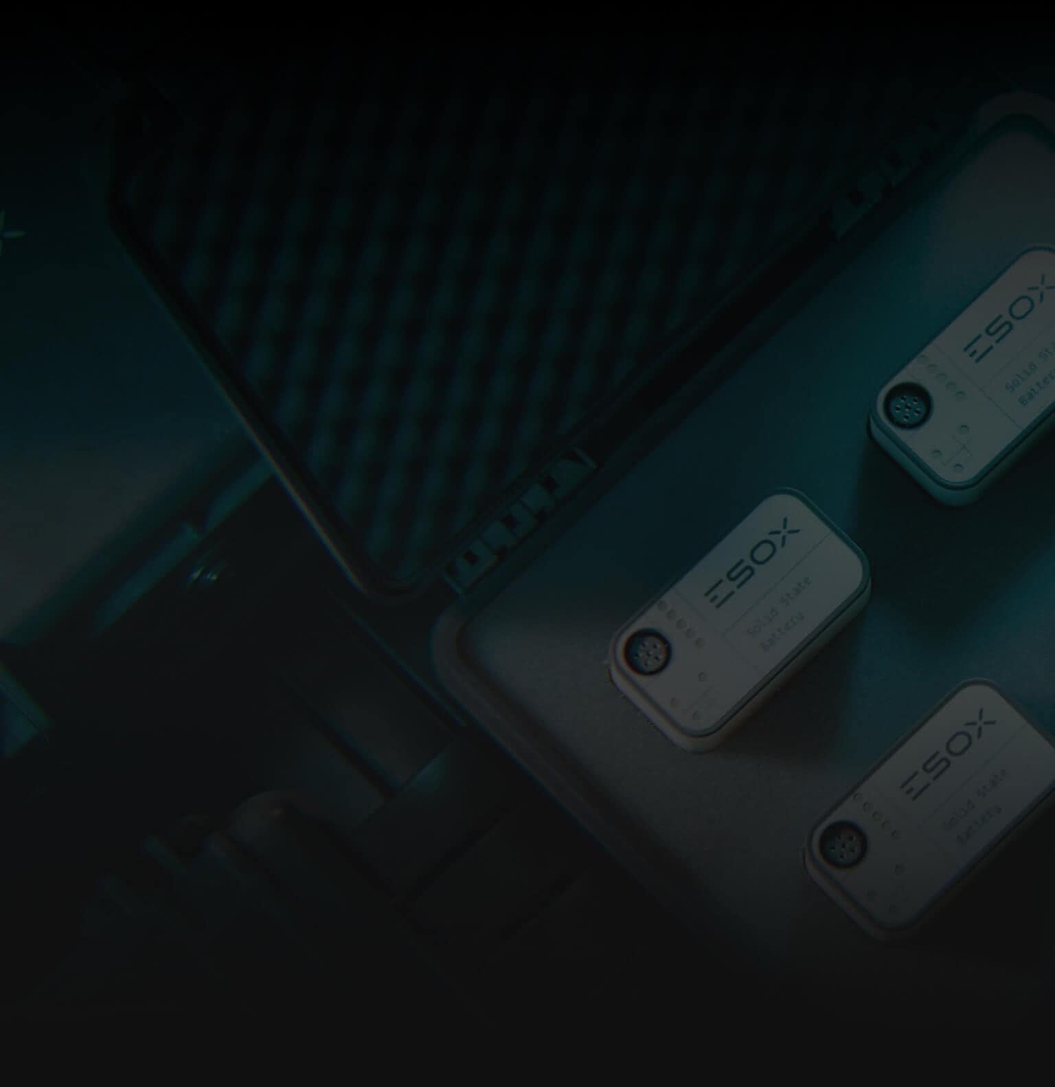 Three small rectangular devices labeled "ESOX" are arranged inside a protective foam case. The image is dark, with the focus on the devices and the case interior.