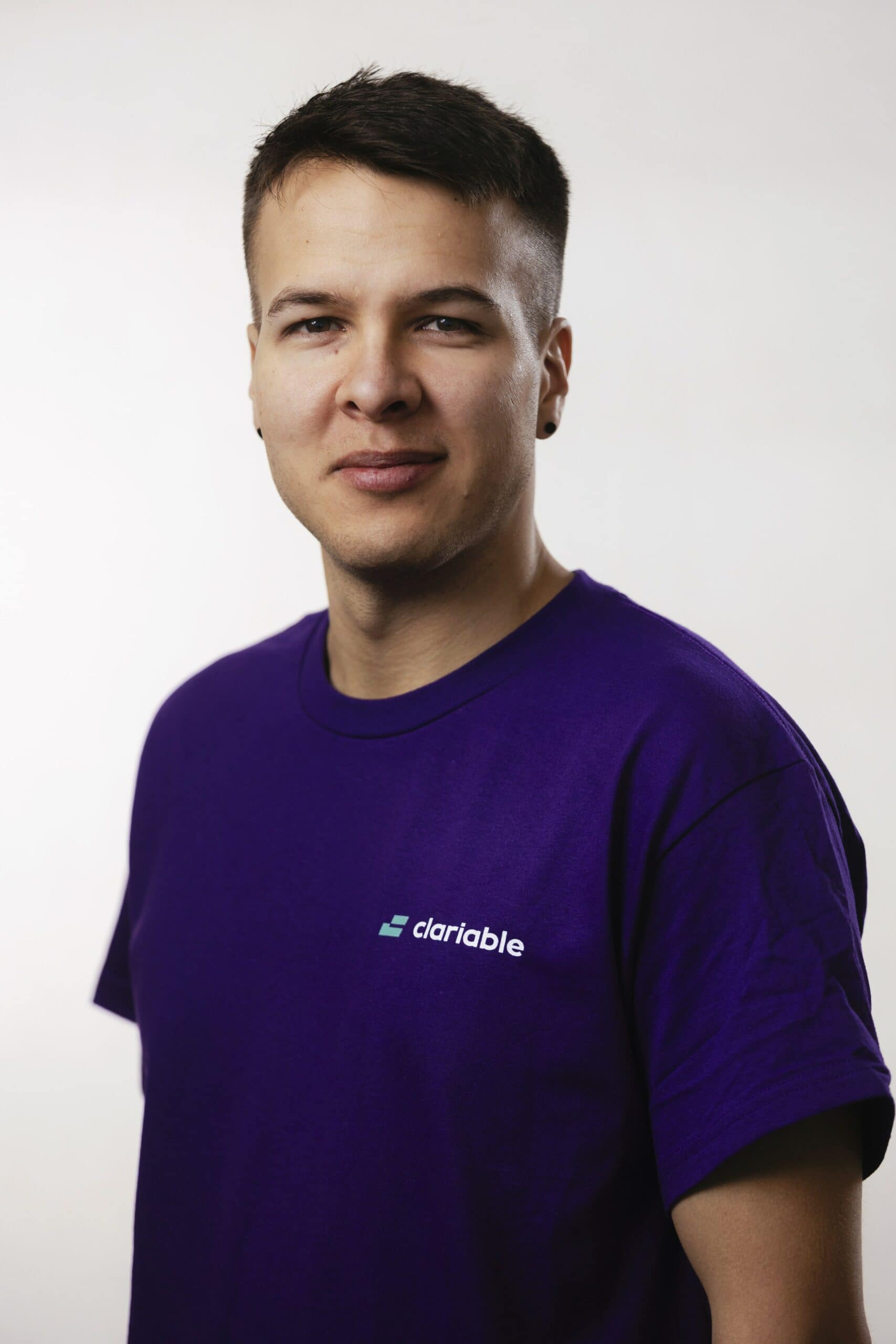 Mario A person wearing a purple t-shirt with the word "clariable" on it stands against a plain background. They have short hair and are looking at the camera with a neutral expression.