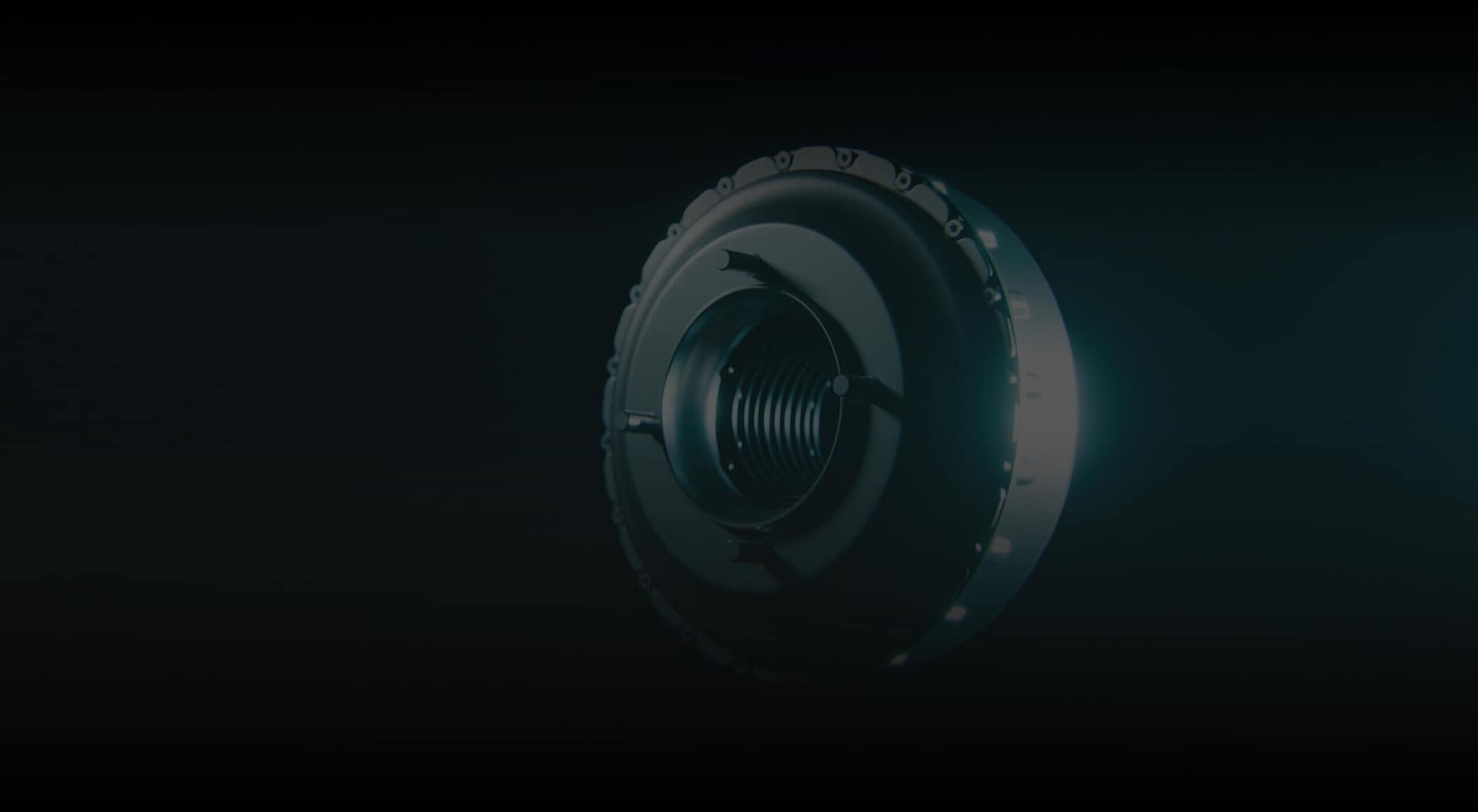 A close-up of a round, metallic mechanical component with a threaded center, illuminated dramatically from the right against a dark background.