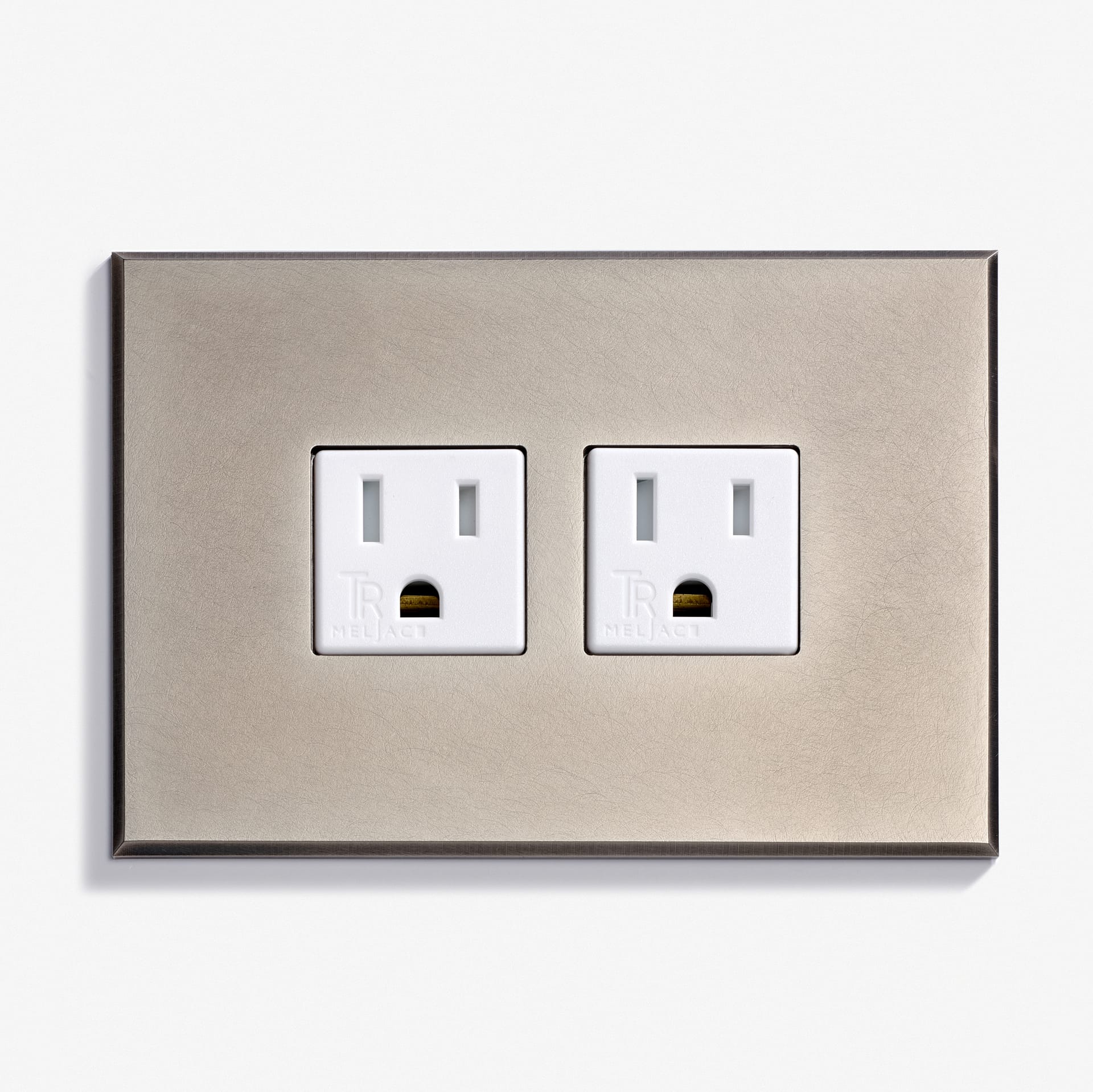 A rectangular dual electrical outlet with white sockets set into a metallic wall plate.
