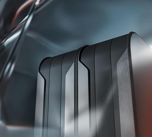 Close-up of two sleek, black and metallic rectangular objects with smooth lines and beveled edges, set against a blurred, abstract background with silvery and blue tones.