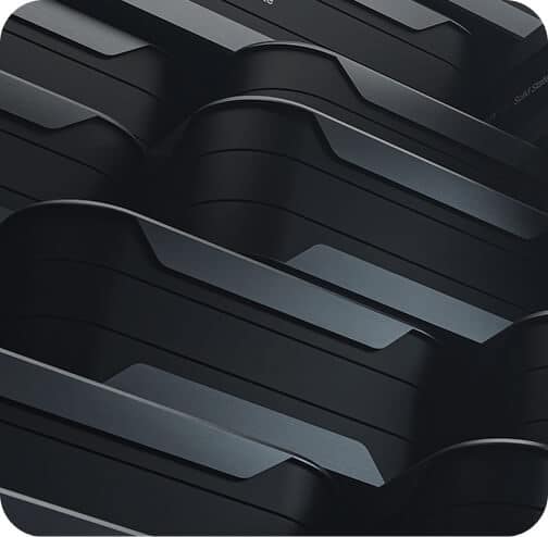 Close-up of stacked, sleek, black rectangular objects with rounded edges and metallic lines, creating a modern, abstract geometric pattern.