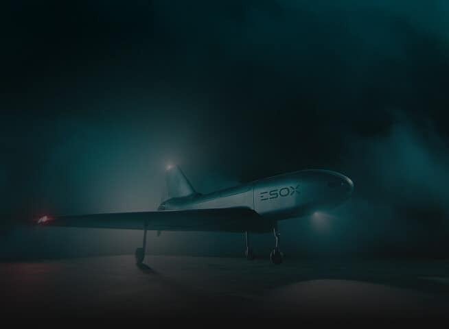 A sleek, futuristic aircraft labeled "ESOX" stands on a misty runway at night, illuminated by soft blue lighting and surrounded by fog.