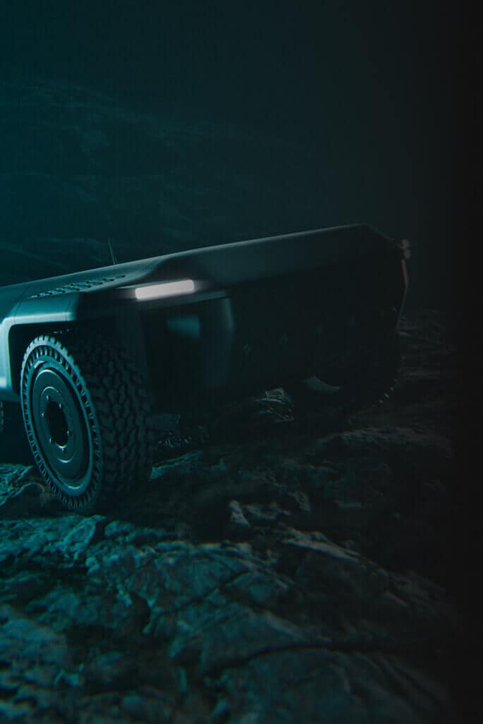 A futuristic, rugged vehicle with large tires and a sleek, angular body is partially visible in dim lighting, positioned on uneven, rocky terrain.