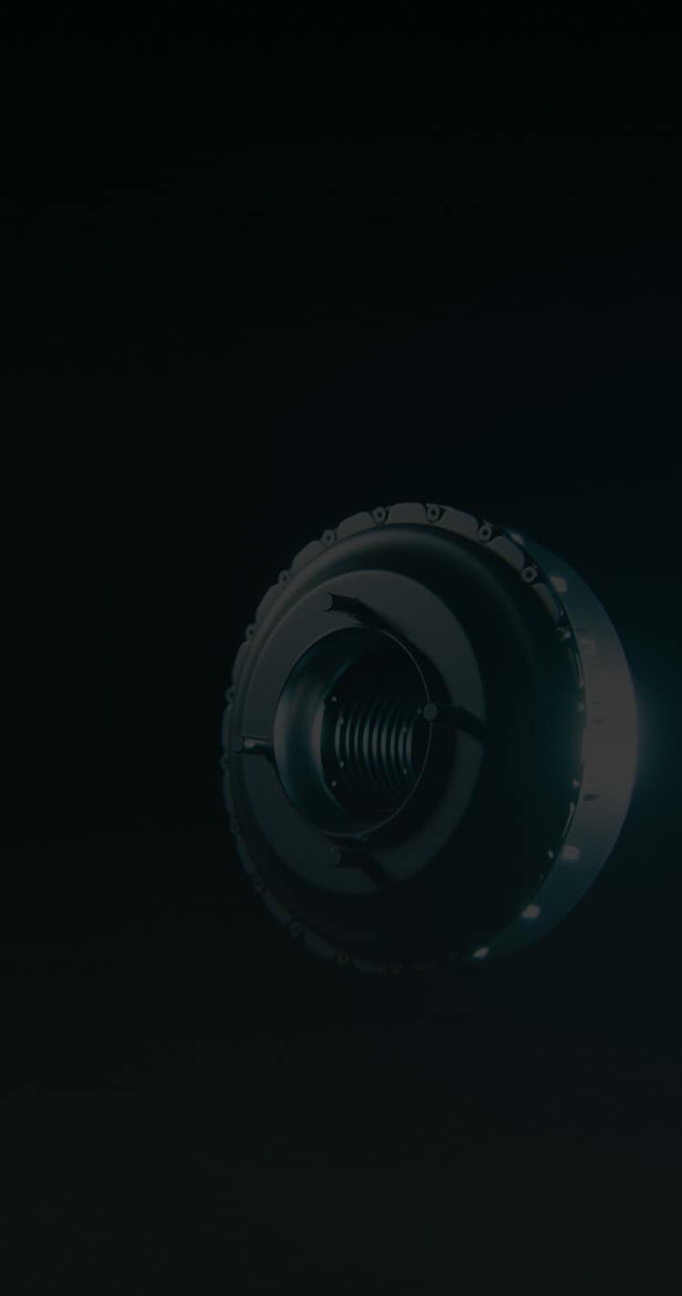 A close-up of a dark, metallic, circular mechanical part with grooves and ridges, set against a black background with soft lighting highlighting its edges.