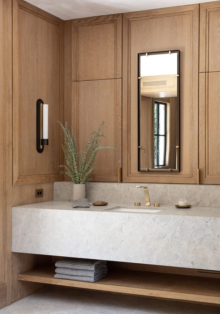 A bathroom with wooden cabinets and marble counter top.