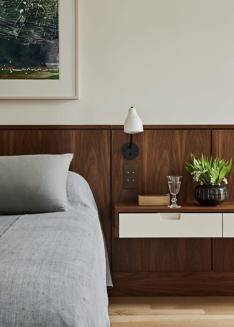 A modern bedroom with a bed and a plant on the side of the bed.
