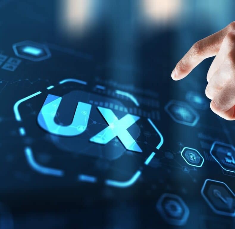 Close-up of a hand interacting with a digital interface displaying the letters "UX" surrounded by various technological icons. The scene conveys a theme of user experience and digital innovation.