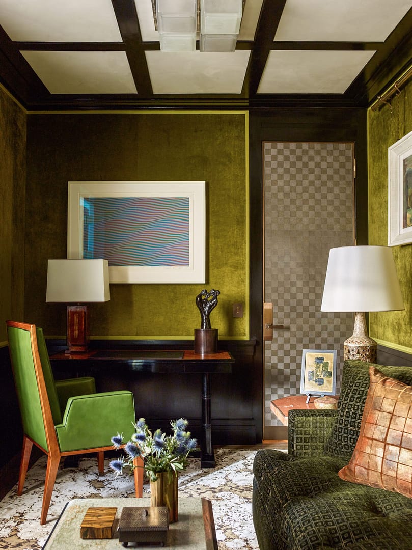 A living room with green walls and furniture.