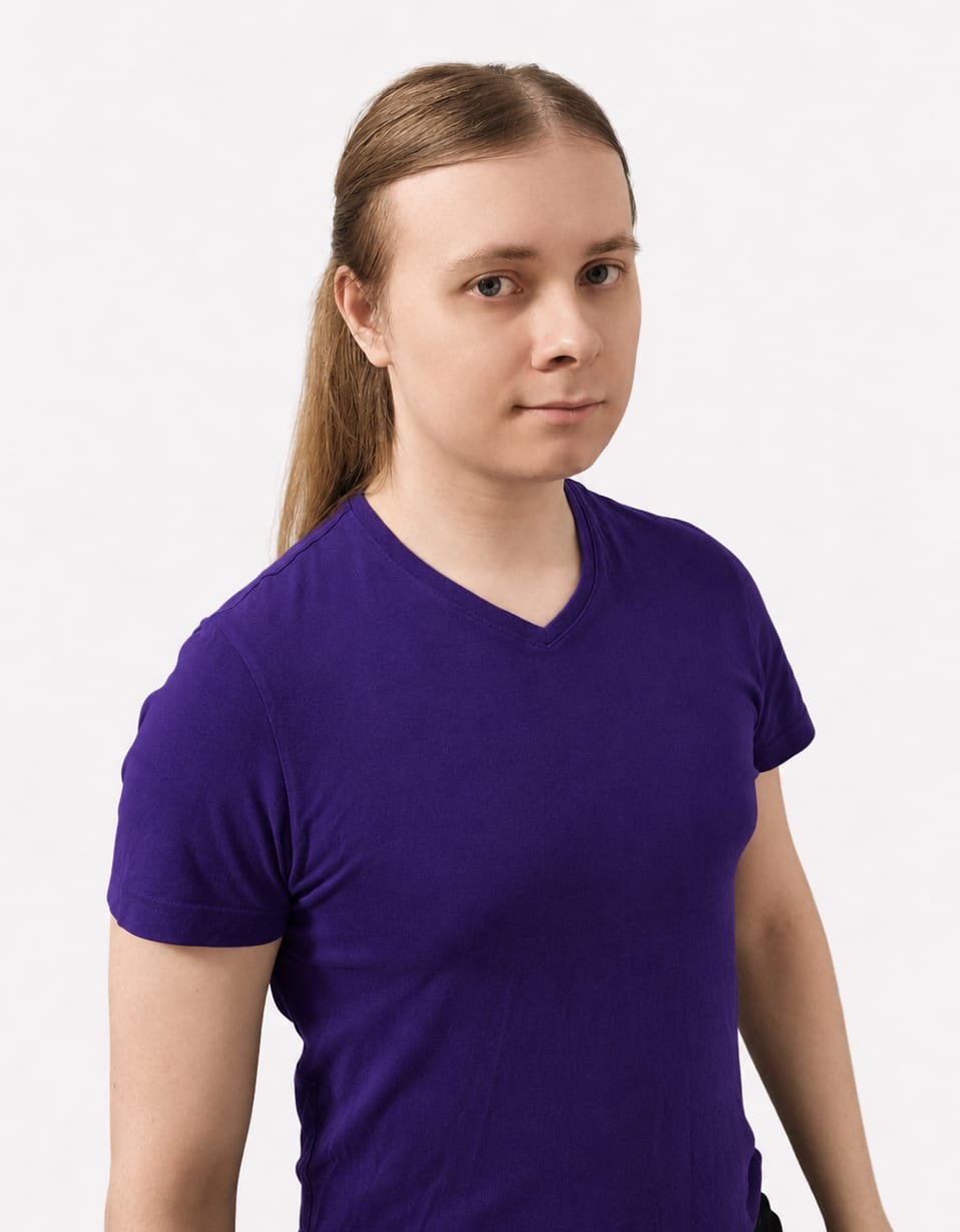 stanislav sirovyi photo A person with long, light brown hair tied back, wearing a purple T-shirt, stands against a plain white background, looking calmly at the camera.